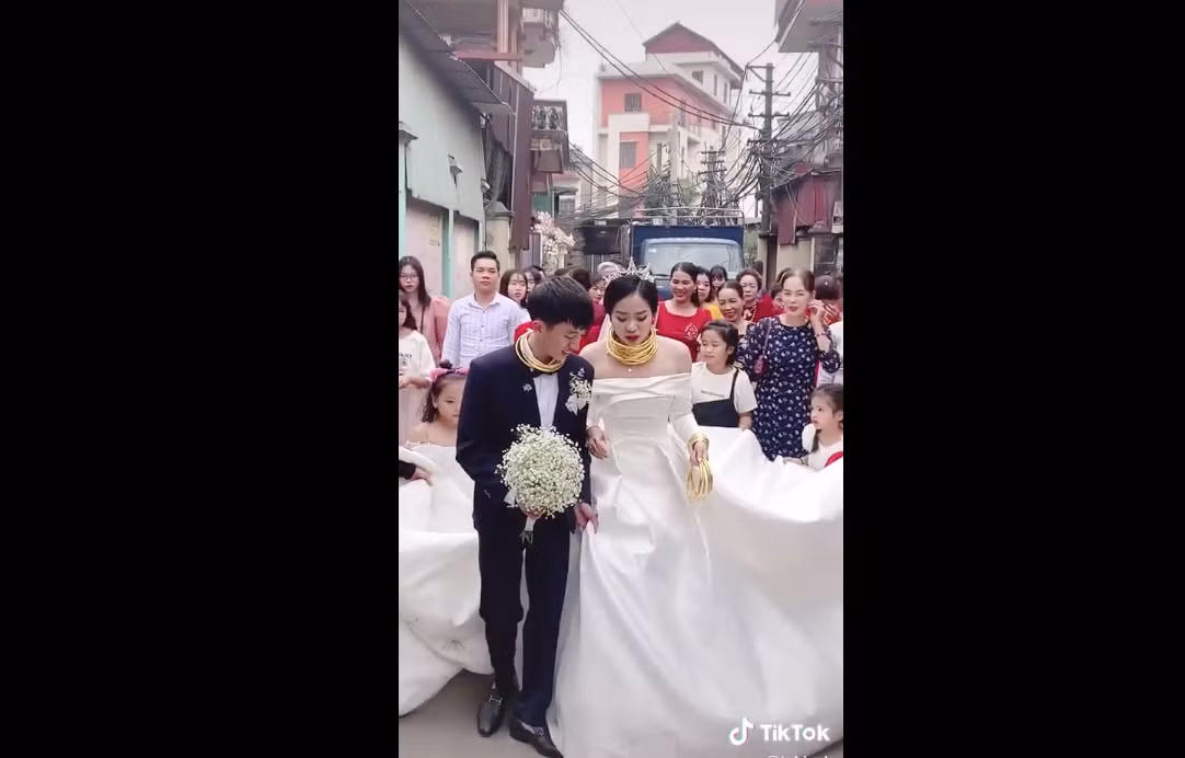 Phần cổ của cô dâu đeo kín vàng nhưng vẫn không hết nên phải cầm cả trên tay cho đỡ "nặng" khiến dân mạng vừa ghen tỵ vừa buồn cười.