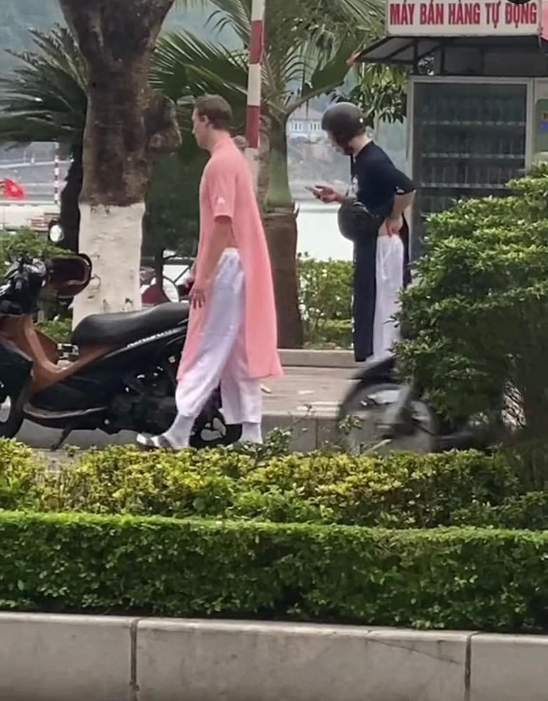 Nhưng điều đáng nói ở đây là một trong 2 anh chàng mặc 1 mẫu áo dài màu hường phấn, là 1 thiết kế dành cho phái nữ, thường là cho các mẹ các bà