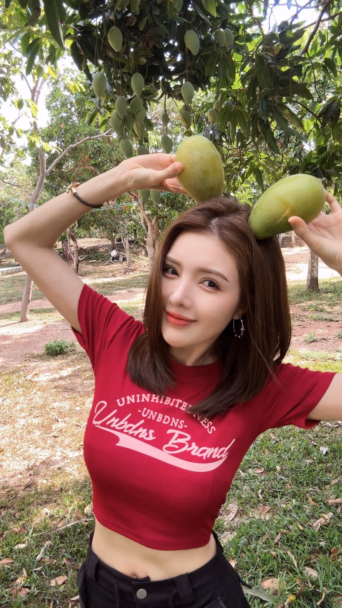 Diện áo croptop màu đỏ phối với chân váy đen năng động, Lilly Luta khoe khoảnh khắc làm "xoài tặc" đầy đáng yêu.