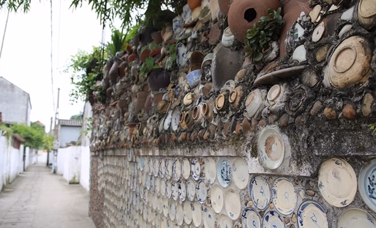 Bức tường bao quanh nhà cũng được gắn đầy bát, đĩa với những hoa văn cổ xưa.