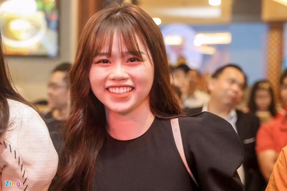 Hot girl sinh năm 1999 diện một bộ trang phục màu đen, ton - sur - ton với bộ vest lịch lãm của bạn trai. Cô nàng xuất hiện với nụ cười rạng rỡ trên môi, luôn chủ động lùi về phía xa khi có người muốn chụp hình cùng Quang Hải. Ảnh: Zing