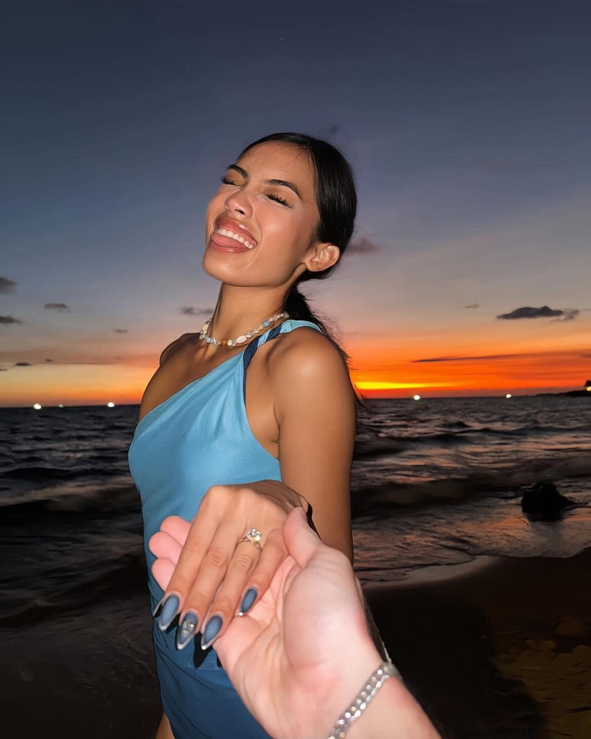 Cô nàng khoe khoảnh khắc hạnh phúc với sự nổi bật nằm ở chiếc nhẫn kim cương ở ngón áp út, phía sau là khung cảnh hoàng hôn ở biển đầy thơ mộng.