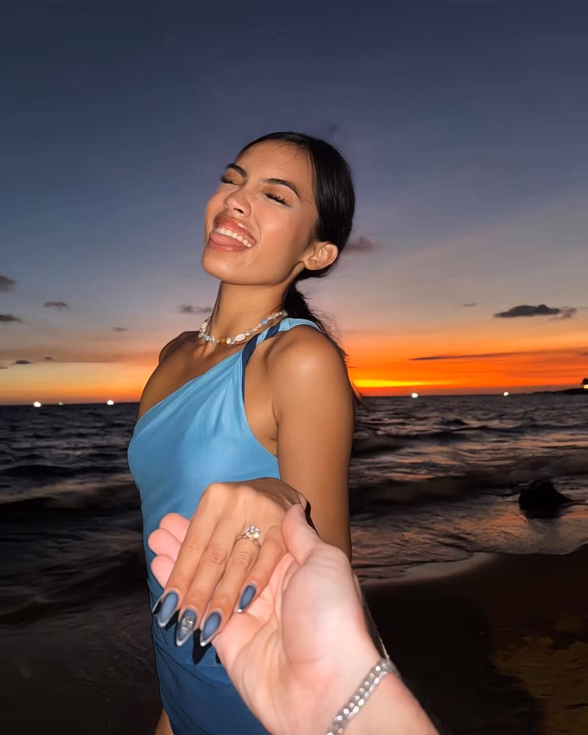 Cô nàng khoe khoảnh khắc hạnh phúc với sự nổi bật nằm ở chiếc nhẫn kim cương ở ngón áp út, phía sau là khung cảnh hoàng hôn ở biển đầy thơ mộng.