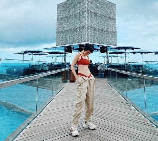 Bảo Anh cũng lên đồ gợi cảm, cá tính, kết hợp bikini và quần ống rộng, phô diễn eo nhỏ, cơ bụng săn chắc lẫn hình xăm chạy dọc bên hông đầy nghệ thuật.