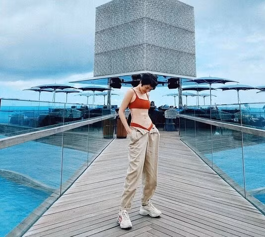 Bảo Anh cũng lên đồ gợi cảm, cá tính, kết hợp bikini và quần ống rộng, phô diễn eo nhỏ, cơ bụng săn chắc lẫn hình xăm chạy dọc bên hông đầy nghệ thuật.