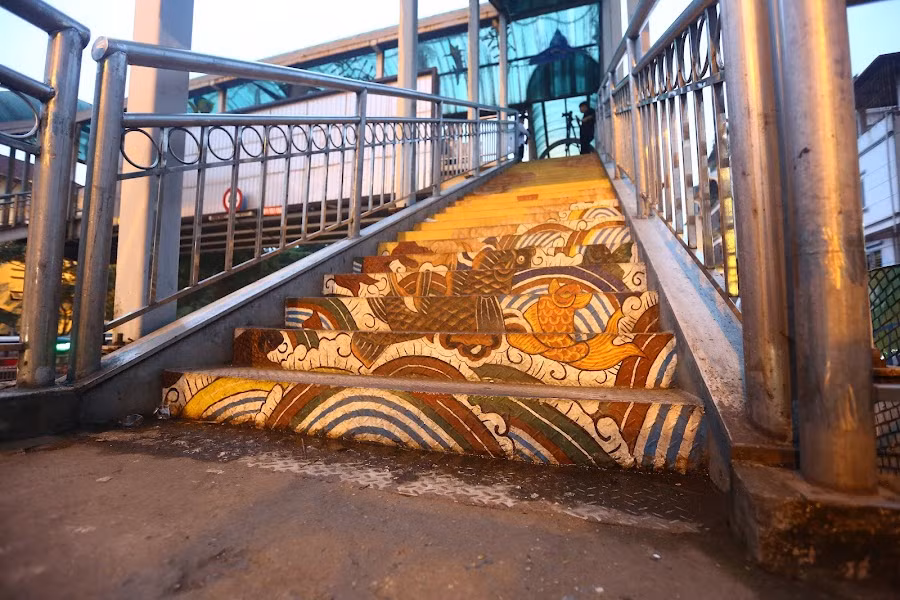 Ngay cả bậc thang bước lên cầu cũng được vẽ lại, con đường dẫn lên cầu trông như lối đi rẽ sóng bước vào đại dương bao la.