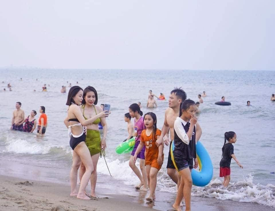 Từ trẻ con đến người lớn đều tranh thủ đi tắm biển.