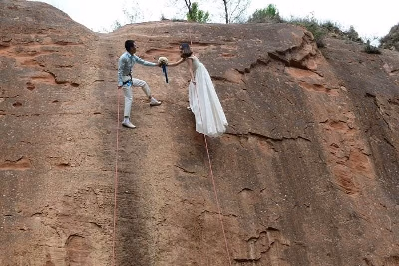 Cô dâu và chú rể treo mình cách mặt đất 30m, cả hai người đều khá vất vả leo lên trong trang phục cô dâu chú rể nhưng họ đều rất vui vẻ tạo dáng. Các thiết bị an toàn cũng được đảm bảo.