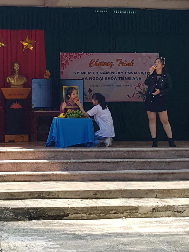 Trong bức ảnh là một nữ sinh đang diễn vai người bà đã khuất. Có vẻ việc đứng im bất động và cầm khung ảnh quá lâu khiến diễn viên "quên" mất mình đang đóng kịch và ăn luôn cả đạo cụ khiến khán giả phì cười.