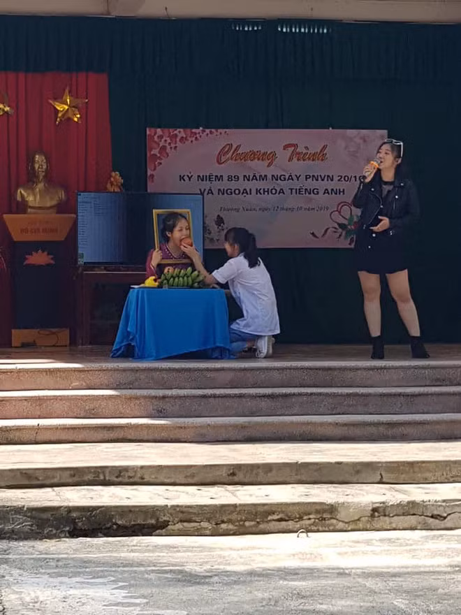 Trong bức ảnh là một nữ sinh đang diễn vai người bà đã khuất. Có vẻ việc đứng im bất động và cầm khung ảnh quá lâu khiến diễn viên "quên" mất mình đang đóng kịch và ăn luôn cả đạo cụ khiến khán giả phì cười.