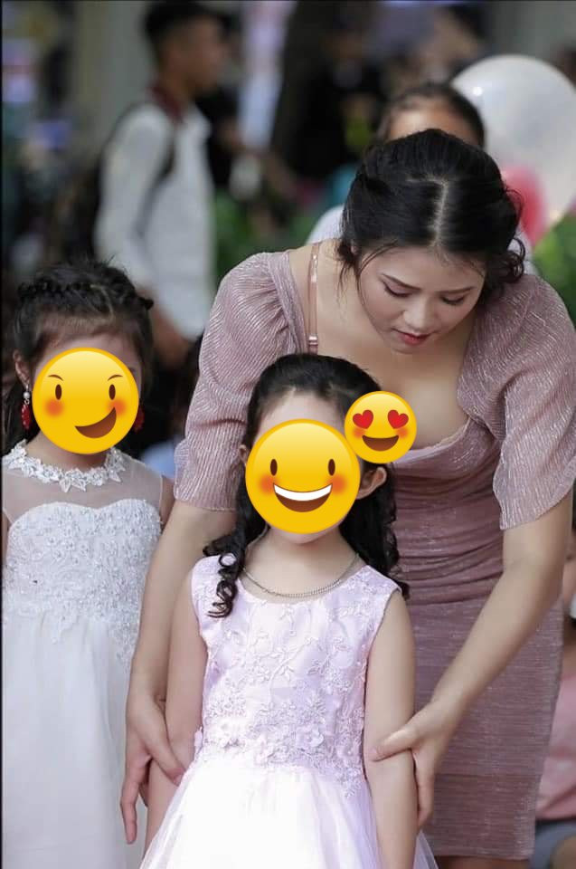 2 bức ảnh được chụp tại Phố đi bộ Hồ Gươm gây sốt mạng xã hội cho thấy một cô giáo trẻ trong bộ váy màu hồng thanh lịch, gương mặt xinh đẹp cùng mái tóc búi gọn gàng. Cô đang tỉ mỉ, chăm chút, lo lắng cho các em nhỏ khiến nhiều người cảm thấy rất yêu mến cô, thậm chí nhiều ông bố muốn quay được về tuổi thơ đi học.
