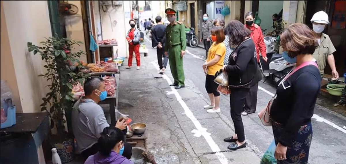 Tất cả mọi người khi tới mua hàng tại khu chợ dân sinh đều đứng nghiêm chỉnh tại vạch đã được kẻ sẵn để giữ an toàn trước khả năng lây lan COVID-19. Đặc biệt, 100% người có mặt tại chợ đều sử dụng khẩu trang.