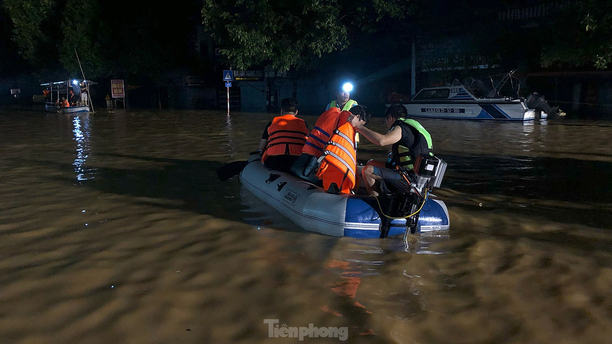 Những chuyến xuồng vẫn đi vào khu vực vùng ngập lụt để đón người ra trong đêm. Ảnh: Hoàng Mạnh Thắng 