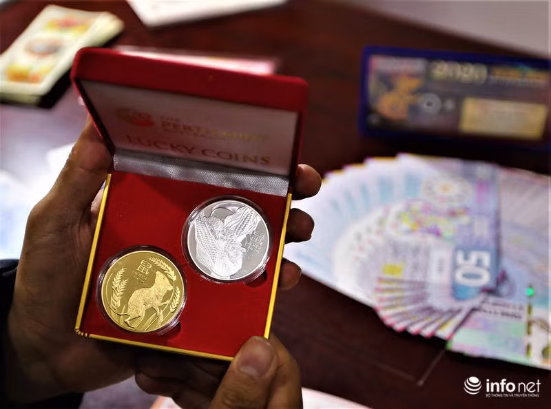 2 đồng xu mạ vàng và mạ bạc được đặt ngay ngắn bên trong hộp nhung đỏ được anh Chính cho biết đã có khách đặt mua rồi.