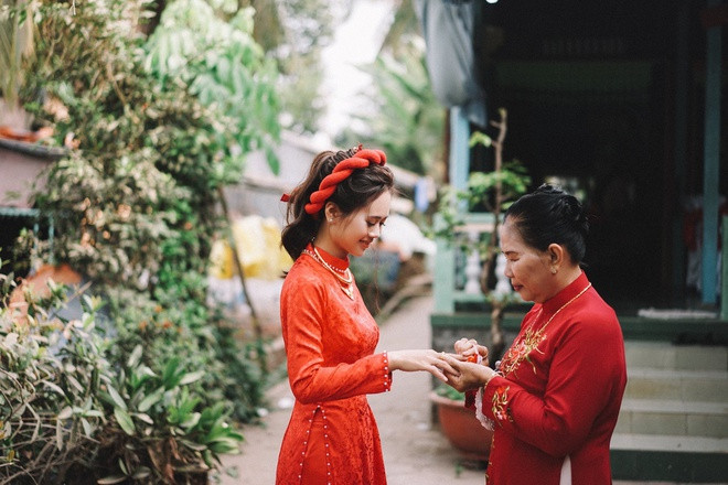 “Mình thích chụp ảnh. Hồi mới quen, đứa ở quê, đứa ở Sài Gòn nên cứ cuối tuần chúng mình lại thay phiên tới thăm đối phương, đưa nhau đi chụp hình. Mình nói thích có giàn hoa giấy trước cổng. Thế là anh chàng đi tận lên thị trấn tìm mua cây giống về nhà trồng. Anh nói: ‘Khi nào cây trổ hoa xum xuê là ngày đó mình cưới nhau’. Trùng hợp là ngày cưới hoa cũng nở rộ”, Đang kể.