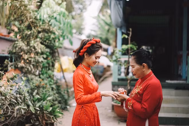 “Mình thích chụp ảnh. Hồi mới quen, đứa ở quê, đứa ở Sài Gòn nên cứ cuối tuần chúng mình lại thay phiên tới thăm đối phương, đưa nhau đi chụp hình. Mình nói thích có giàn hoa giấy trước cổng. Thế là anh chàng đi tận lên thị trấn tìm mua cây giống về nhà trồng. Anh nói: ‘Khi nào cây trổ hoa xum xuê là ngày đó mình cưới nhau’. Trùng hợp là ngày cưới hoa cũng nở rộ”, Đang kể.