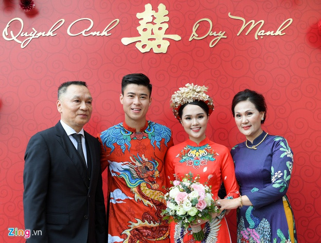 Không kém cạnh, bạn gái Duy Mạnh cũng cực lồng lộn trong lễ ăn hỏi. Cô diện áo dài đỏ đồng màu với gam màu đám cưới, cùng với đó là chiếc mấn đính hoa, ngọc vô cùng cầu kỳ.