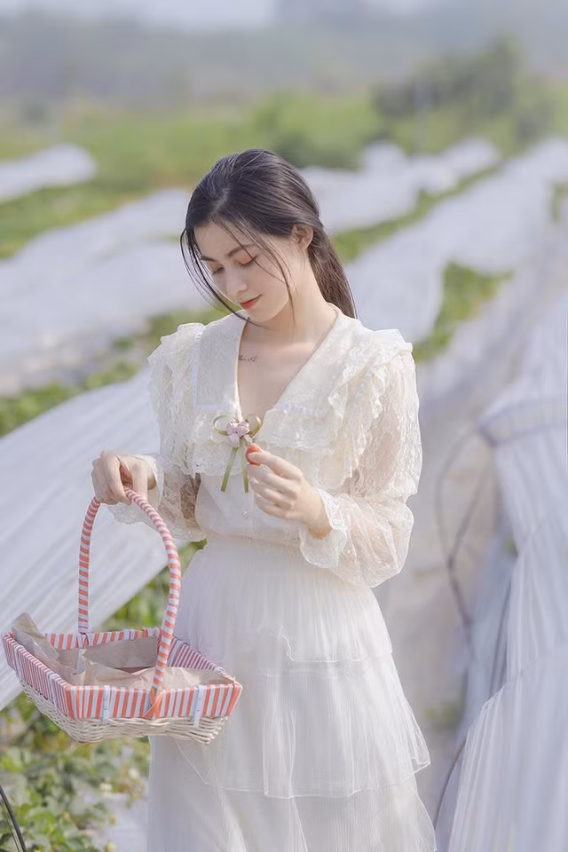 Mới đây, bộ ảnh thực hiện trong vườn dâu của Khánh Linh được đăng tải thu hút sự chú ý của cộng đồng mạng. Cách trang điểm nhẹ nhàng, buộc tóc đơn giản, bộ váy trắng dài thướt tha cùng nước da trắng mướt khiến hot girl sinh năm 1995 được ví trong trẻo như sương mai.