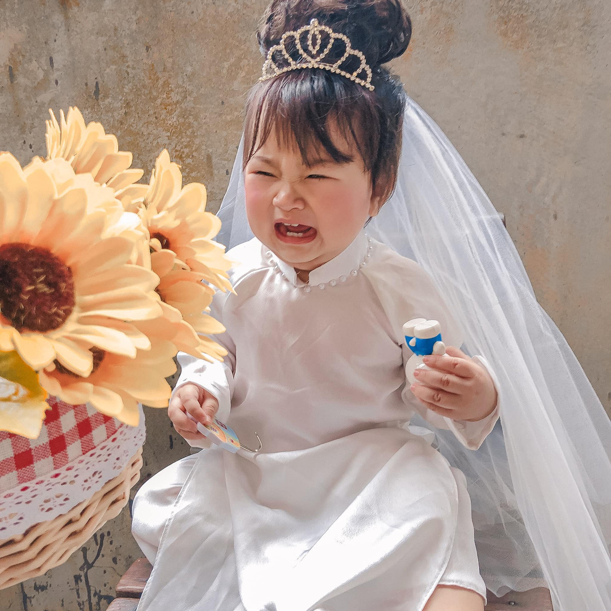 Biểu cảm cực đáng yêu của em bé khiến ai nấy đều phải tan chảy. Cô dâu gì mà còn khóc nhè đòi mẹ thế này. Chiếc má bánh bao ửng hồng, phúng phính của "cô dâu" càng khiến dân tình chao đảo.