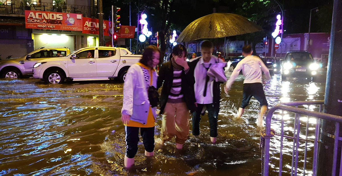 Tại một số con phố ở Hà Nội đã bắt đầu xuất hiện tình trạng ngập úng. Dù vậy, mưa cũng đã bắt đầu tạnh nên lượng người đổ ra đường đông hơn.
