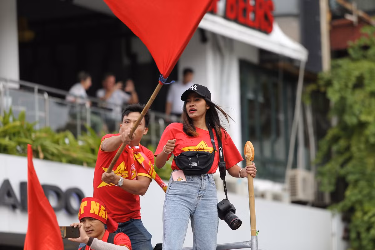 Hình ảnh cô nàng trong trang phục áo đỏ như bao người khác đứng trên xe liên tục hô hào cổ vũ trận bóng đá tối nay khiến nhiều người thích thú.