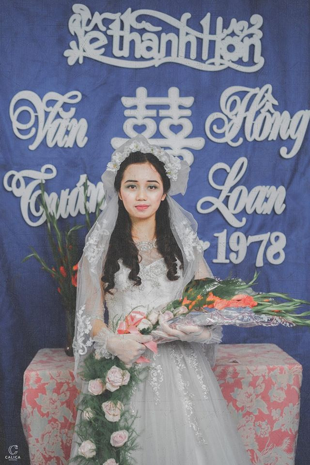 Bộ váy của cô dâu diêm dúa, nhiều hoa văn, trông cực rối mắt nhưng không hề dễ tìm. Hiện tại, các mẫu váy cưới này gần như không còn, chính bởi thế mà nhiều dân mạng đặt ra nghi vấn rằng có lẽ ê kip chụp ảnh cưới đã phải đặt may riêng.