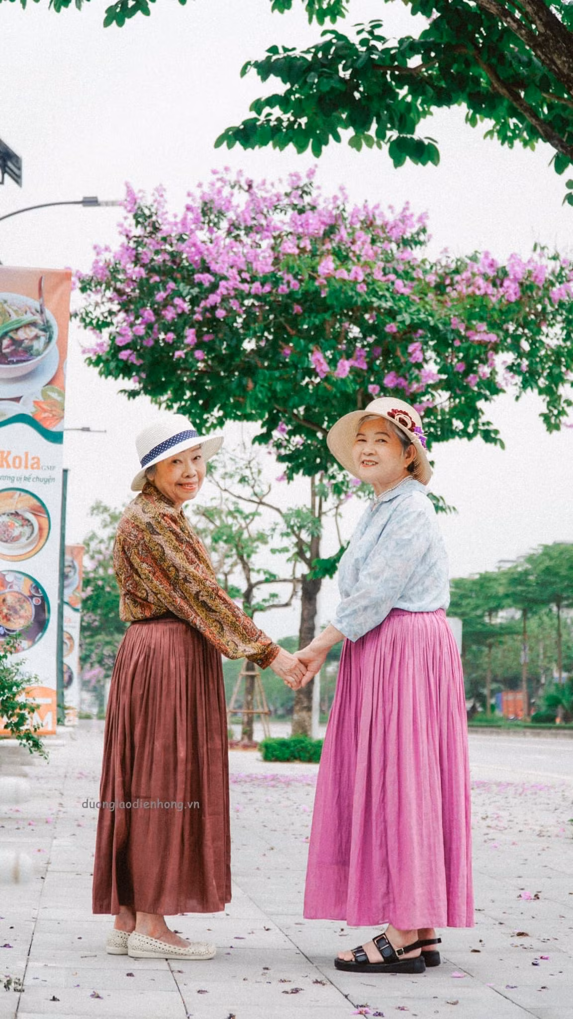 Bộ ảnh chụp cùng bằng lăng của 2 cụ bà đã khiến nhiều người "thả tim" vì quá đáng yêu. 2 cụ như những cô bạn thân trẻ tuổi nắm tay nhau tạo dáng dưới tán bằng lăng tím xinh.