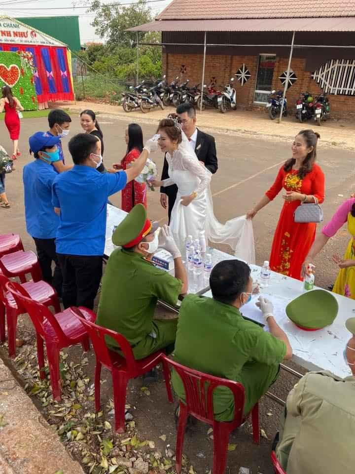 Cô dâu, chú rể và khách mời ai cũng hào hứng, tuân thủ quy trình kiểm tra của các cán bộ công an để phòng tránh dịch Covid-19.