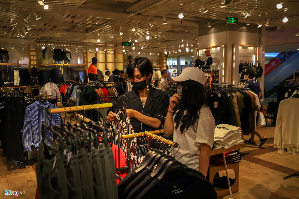 Khác hẳn với khung cảnh chen chúc, xếp hàng để mua sắm và thanh toán vào các buổi tối thường nhật, những cửa hiệu thời trang nổi tiếng H&amp;M, Zara, Uniqlo, Pull&amp;Bear chỉ còn vài bạn trẻ bịt khẩu trang đến xem hàng.