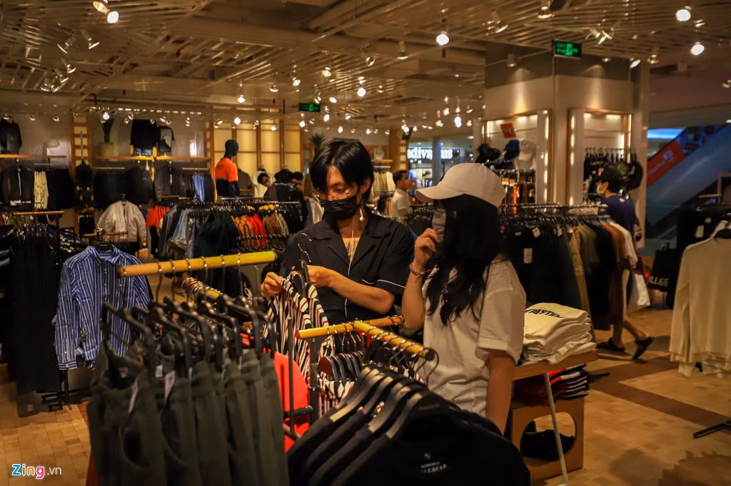 Khác hẳn với khung cảnh chen chúc, xếp hàng để mua sắm và thanh toán vào các buổi tối thường nhật, những cửa hiệu thời trang nổi tiếng H&amp;M, Zara, Uniqlo, Pull&amp;Bear chỉ còn vài bạn trẻ bịt khẩu trang đến xem hàng.