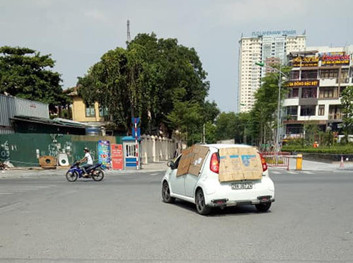 Không chỉ có những người đi xe máy, những tài xế xe ô tô cũng dùng bìa cat-tong để che nắng chiếu vào trong xe.