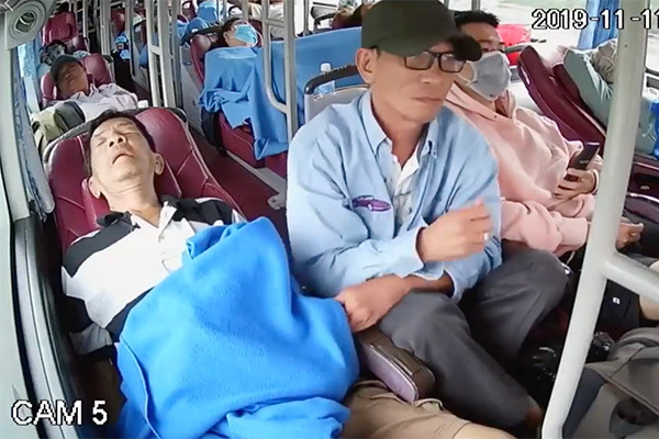 Nguoi dan ong trang tron moc tui tren xe khach gay bang hoang