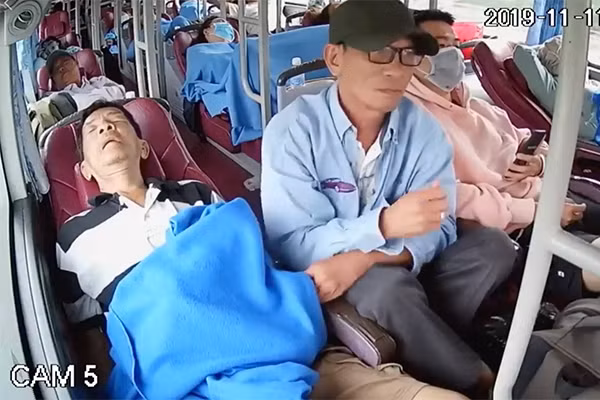 Nguoi dan ong trang tron moc tui tren xe khach gay bang hoang