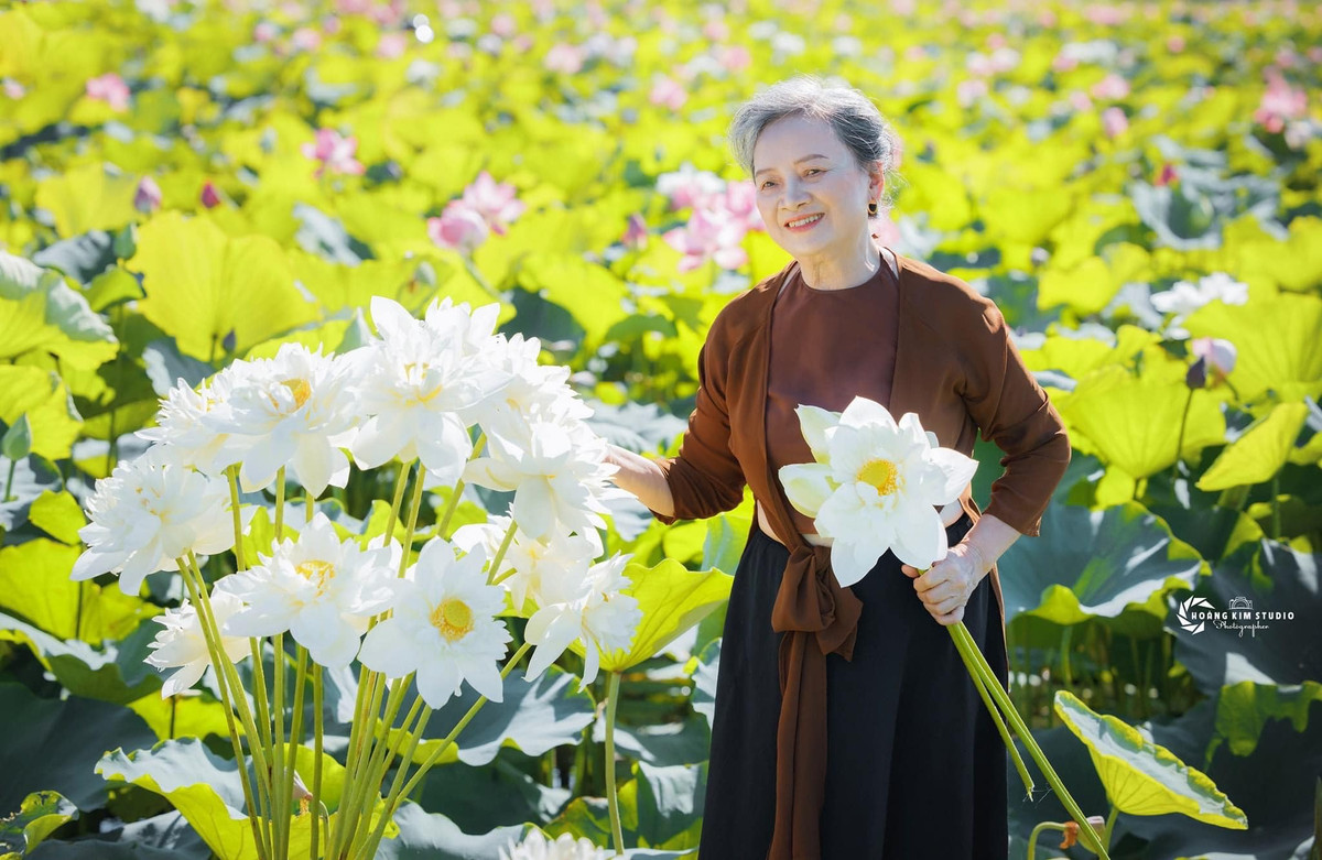 Cụ bà diệm yếm phía trong, bên ngoài khoác chiếc áo cùng màu, kết hợp cùng chân váy đụp màu đen.