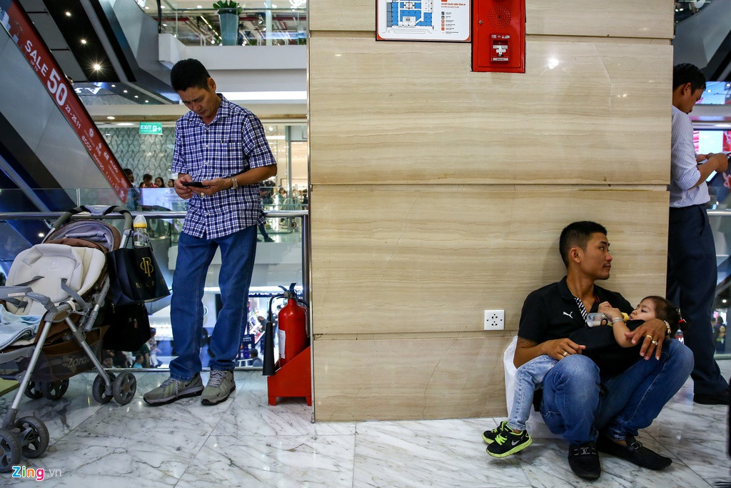 Nhiều người đàn ông sẵn sàng ôm, dỗ dành con cho vợ yên tâm mua sắm. Ảnh: Zing.