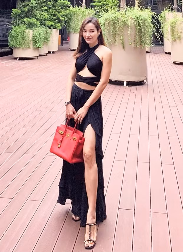 Sau phiên bản màu trắng, Phương Trinh Jolie tiếp tục diện bộ đồ cắt xẻ ''hiểm hóc'' tuyền đen, nhấn nhá bằng túi Hermès đỏ rực. Thêm đôi sandals cao gót, cô nàng đã có phép cộng lý tưởng, chẳng những làm bật lợi thế chân dài mà còn khoe được 3 vòng quyến rũ.