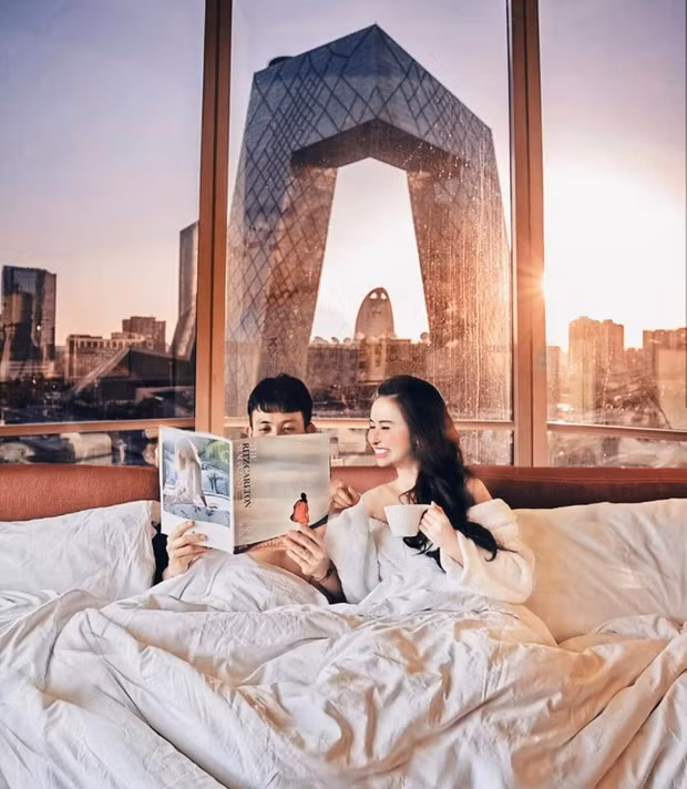 Bức ảnh sống ảo được Minh Nhựa đăng hôm 25/6, ghi lại cảnh 2 vợ chồng đại gia họ Phạm cùng nhau tận hưởng chuyến nghỉ dưỡng tại 1 phòng khách sạn xa hoa với 3 mặt kính trông ra thành phố phía sau.