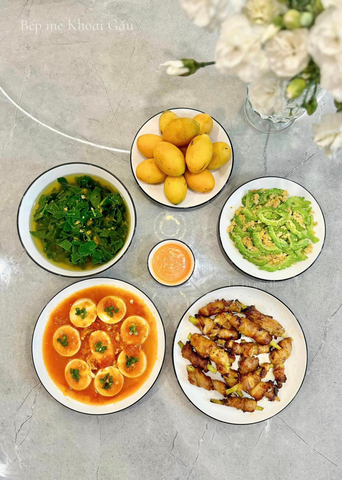 Thực đơn gồm có: Đậu non sốt cà chua, thịt ba chỉ cuộn măng tây nướng, mướp đắng xào trứng, canh cua rau mùng tơi, tráng miệng: quả thanh trà.