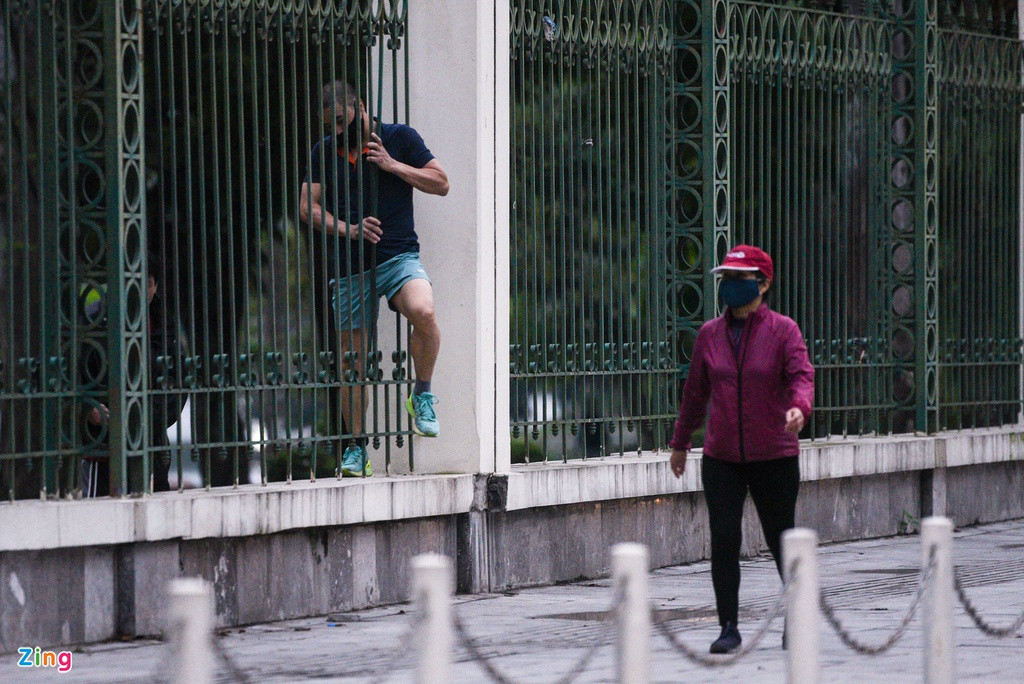 Một số tìm cách vào phía trong công viên để tập thể dục. Tại tường rào mặt phố Nguyễn Đình Chiểu có một vài kẽ hở, dù lách qua rất khó khăn nhưng người đàn ông này vẫn cố gắng trèo qua.