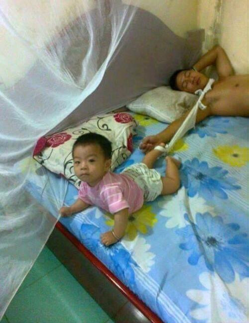 Khi bạn vừa buồn ngủ mà vừa phải trông con thì cách tốt nhất là buộc luôn chúng vào mình.