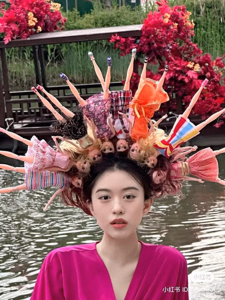 Một cô gái ở Trung Quốc cũng đã theo trend này, thế nhưng thay vì cài hoa, cô nàng cài toàn...búp bê.