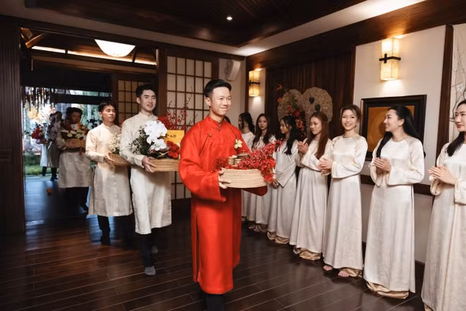 Không gian làm lễ mang tông nâu gỗ chủ đạo, bài trí kết hợp hoa tươi, điểm xuyết tông màu đỏ mang đến sự ấm áp và may mắn trong đám cưới Á Đông.
