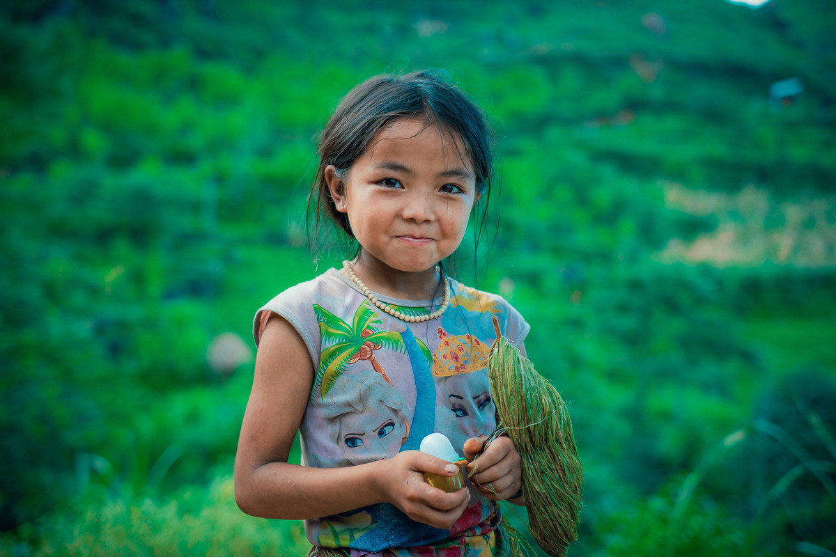 Trái ngược với làn da bánh mật và gương mặt lấm len, đôi mắt em rực sáng, có hồn.
