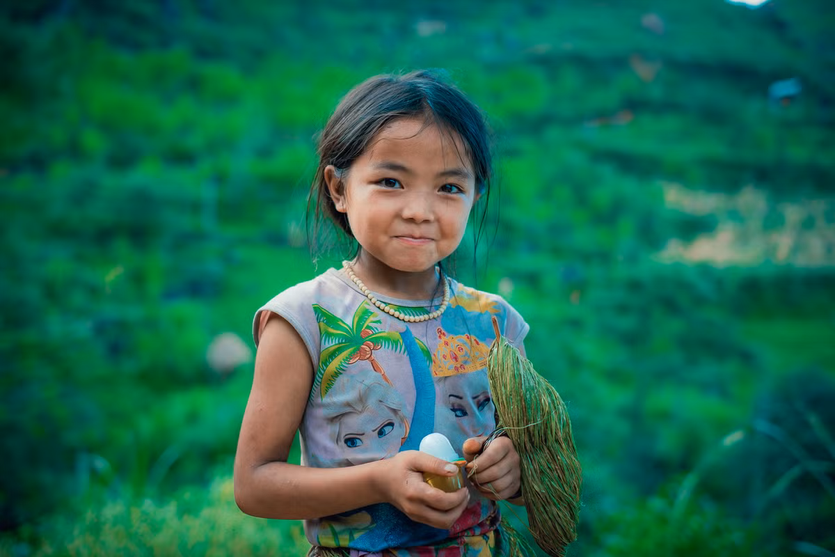 Trái ngược với làn da bánh mật và gương mặt lấm len, đôi mắt em rực sáng, có hồn.