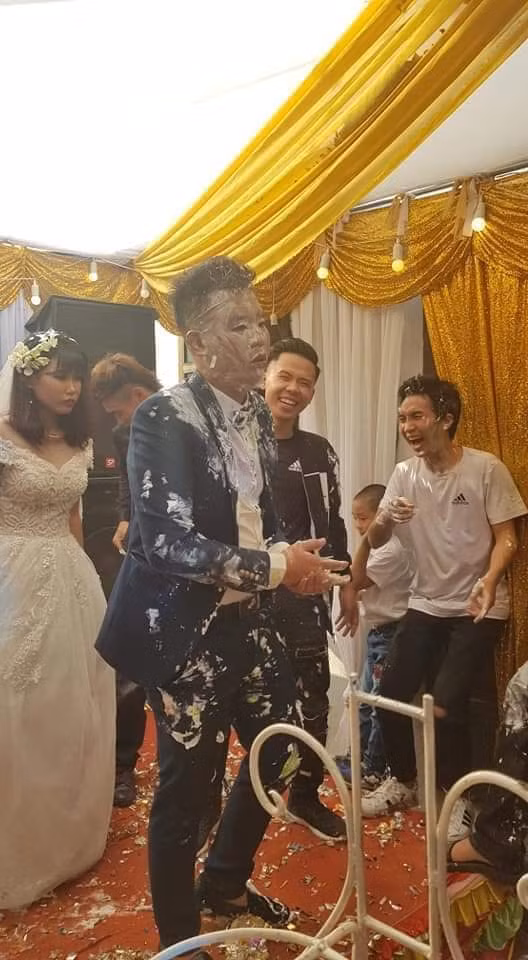 Mới đây, nhiều diễn đàn trên mạng xã hội cùng đăng tải chùm ảnh chú rể thất thần đứng trong đám cưới, trên mặt và người là đầy những bánh kem trông vô cùng đáng thương.