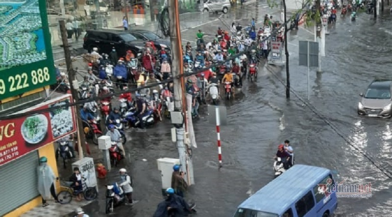 Hai bên đường, hàng trăm người đi xe máy dừng chờ nước ngập mới dám về nhà dẫn đến tình trạng ùn tắc sau đó