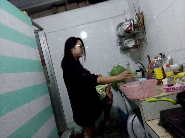 Vừa nấu cơm, vừa ôm con là chuyện quá thường ngày. Thử hỏi có người đàn ông nào làm được việc này không?