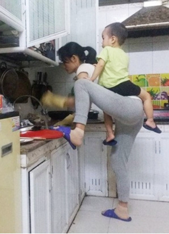 Hình ảnh người mẹ phải vừa rửa bát, nấu cơm, vừa trông con nhỏ vì quấy khóc xuất hiện trên mạng xã hội khiến ai nấy đều rớt nước mắt.
