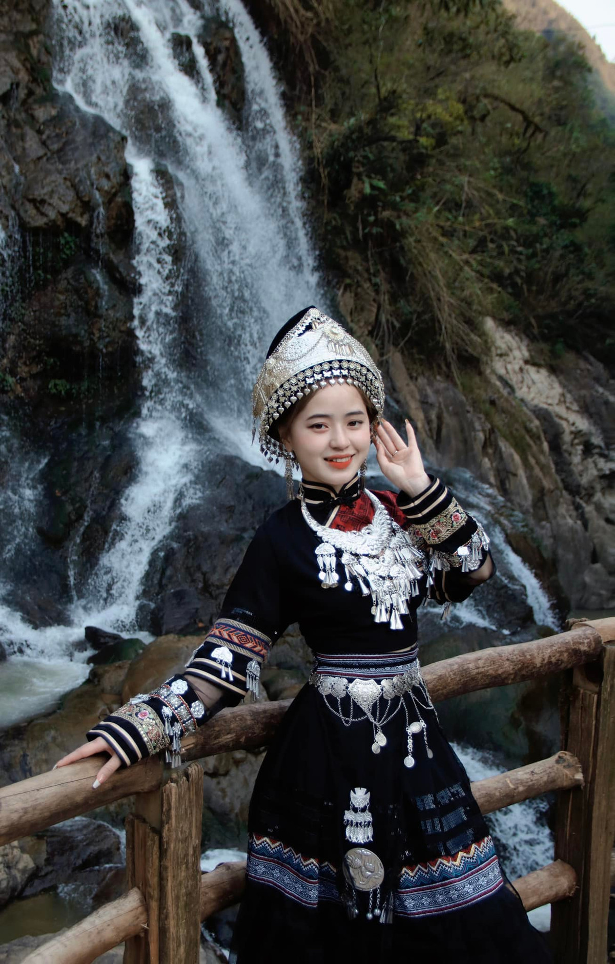 Vương Sinh trong trang phục truyền thống của dân tộc, khoe dáng bên thác nước.