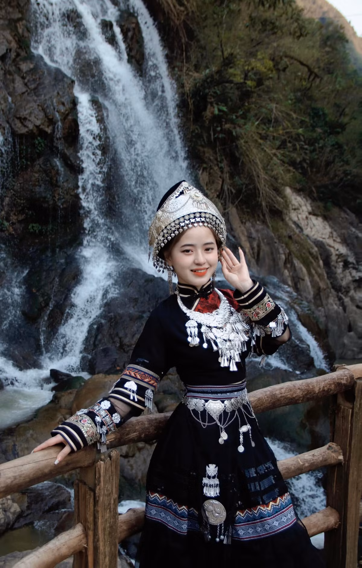 Vương Sinh trong trang phục truyền thống của dân tộc, khoe dáng bên thác nước.